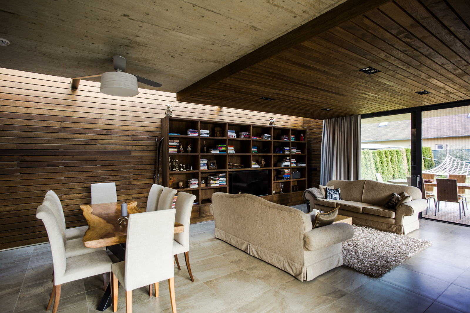 Dřevěná knihovna se stropem v kombinaci beton, dřevo, jídelní masivní stůl teak